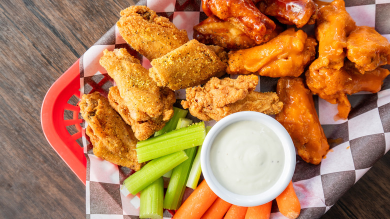 Fried seasoned chicken wings with Buffalo wings and ranch, along with celery and carrot sticks.