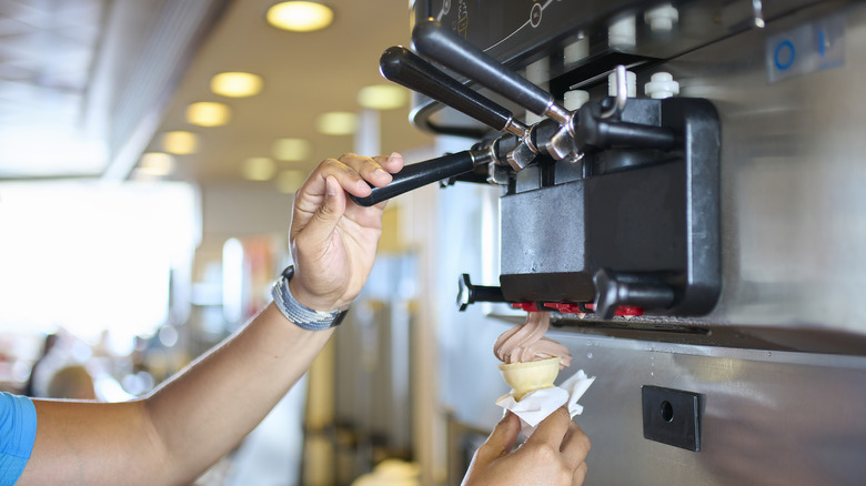 Person using a self-serve soft serve ice cream machine