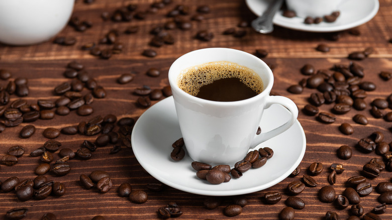 Cup of black coffee on top of coffee beans