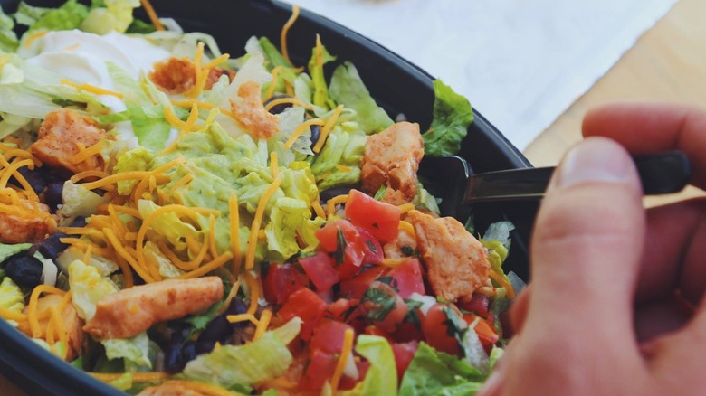 hand sticking a fork into a Taco Bell cantina bowl
