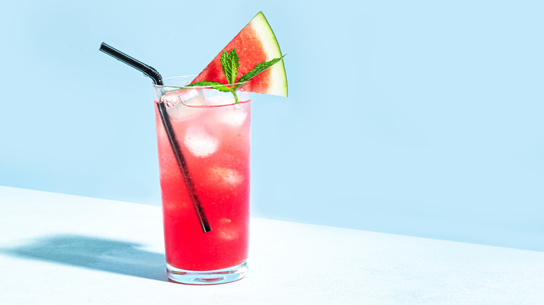 A watermelon drink garnished with mint and a watermelon wedge.