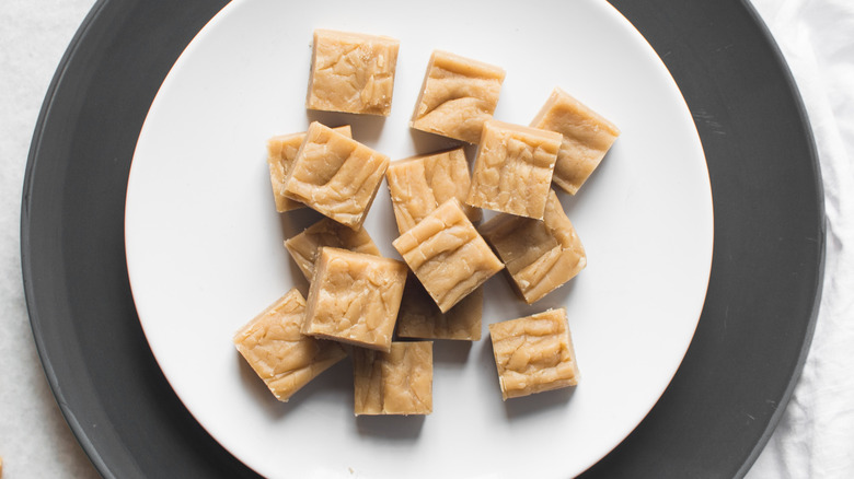 Peanut butter fudge squares on a black and white plate