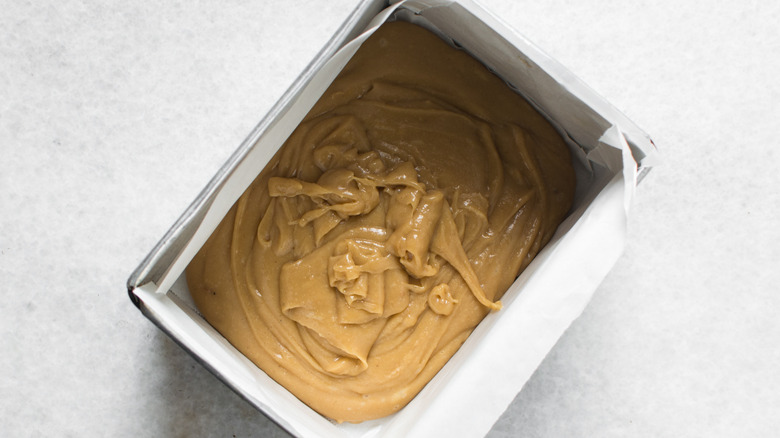 Peanut butter fudge mixture being set in a lined baking tray
