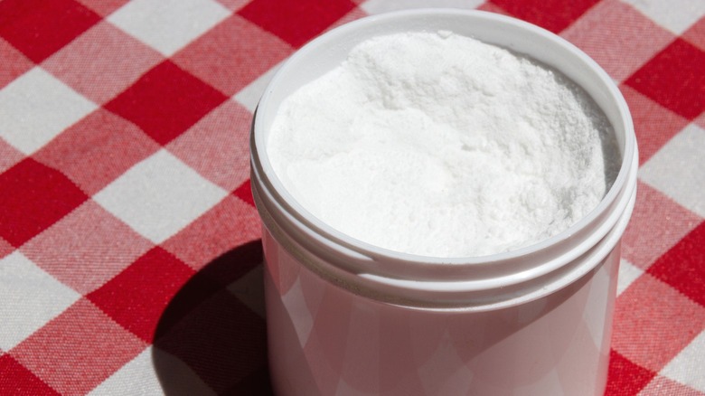 A small container of cream of tartar on a checkered cloth