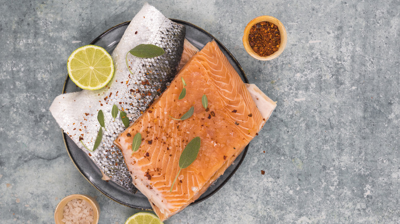 Skin-on raw salmon filets in a glass dish
