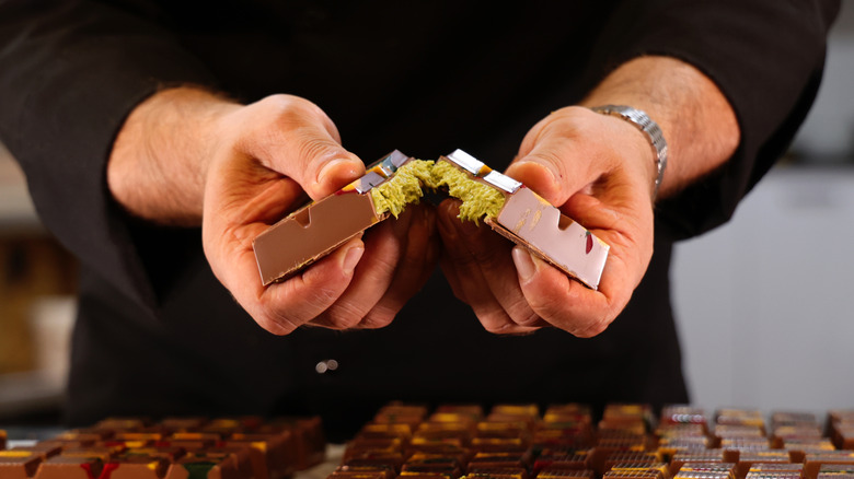 Hands break open Dubai chocolate bar