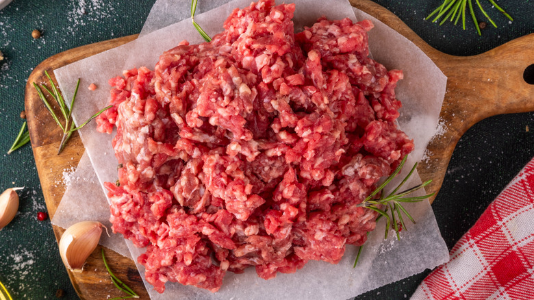 Top view of raw ground beef on parchment paper-lined cutting board