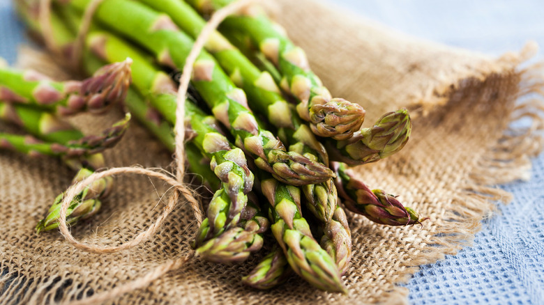 Bunch of raw asparagus on a woven surface
