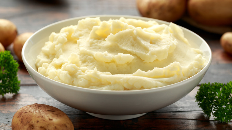 Thick and creamy mashed potatoes in white bowl