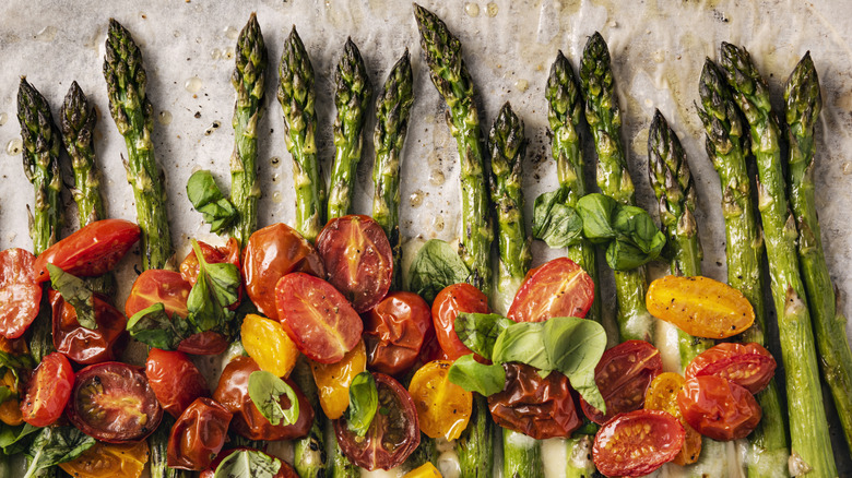Roasted asparagus on sheet tray with cherry tomatoes.