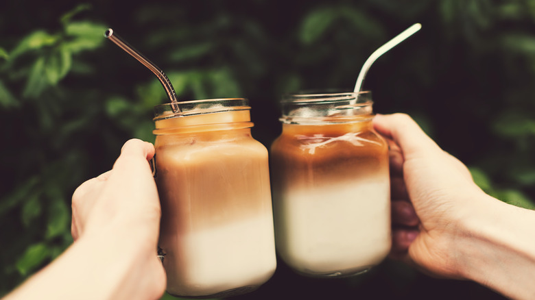 Two jars of coffee with metal straws.