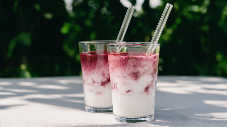 Two smoothies with glass straws.