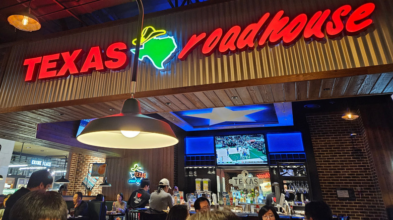 Customers seated by the bar inside a Texas Roadhouse restaurant