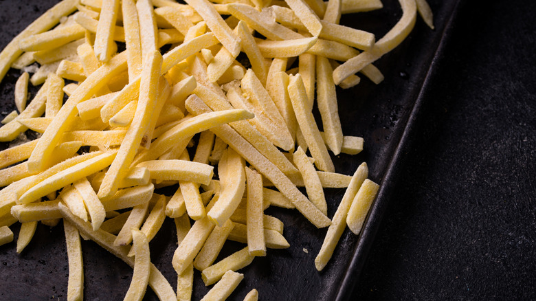 Frozen French fries on a baking pan