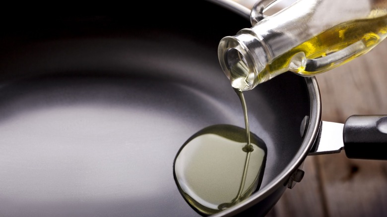 Olive oil being poured into a nonstick pan